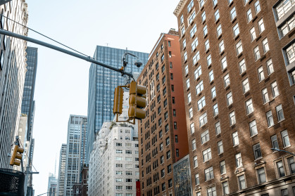 Yellow traffic light with NYC buildings in the background