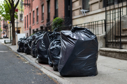 Black Garbage Bags sit on a Residential Street in Greenwich Village of New York City.