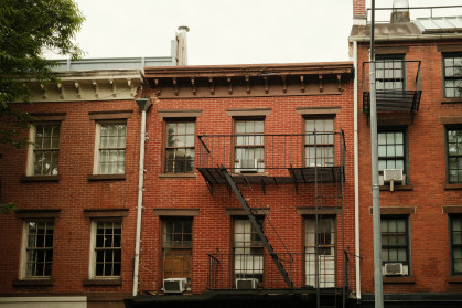 Classic pre-war style brick apartment buildings stand closely together, showing the density of new york city