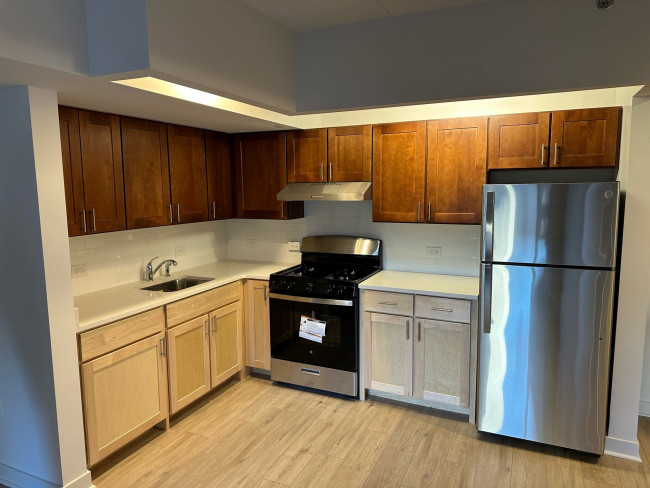 Kitchen with appliances, white countertop and hardwood floors