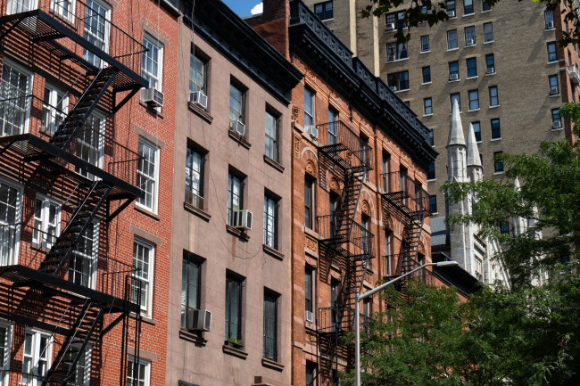 Row of Colorful Old Brick Residential Buildings with Fire Escapes in Greenwich Village of New York City