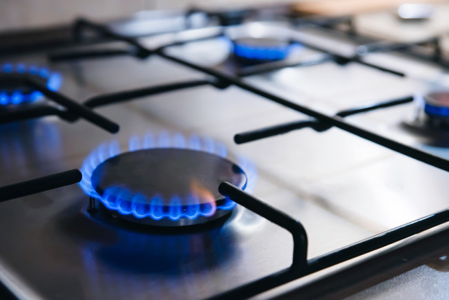 Gas kitchen stove cook with blue flames burning