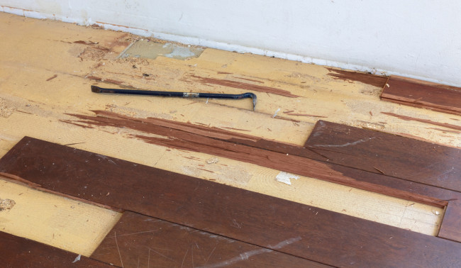 Wood floor partially removed with a tool for levering planks