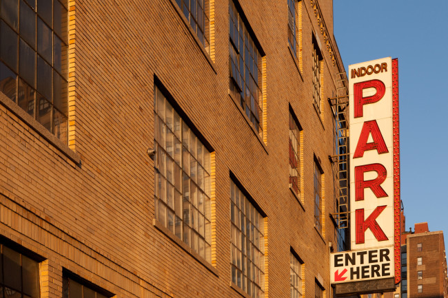 Building garage parking sign during sunset on the west side of Manhattan, New York City.