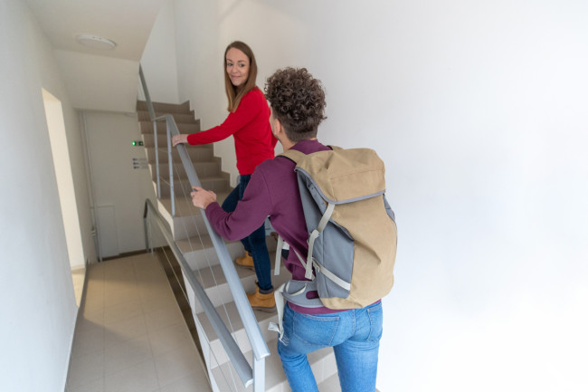 tourists climbing the stairs to their short-term rental in nyc