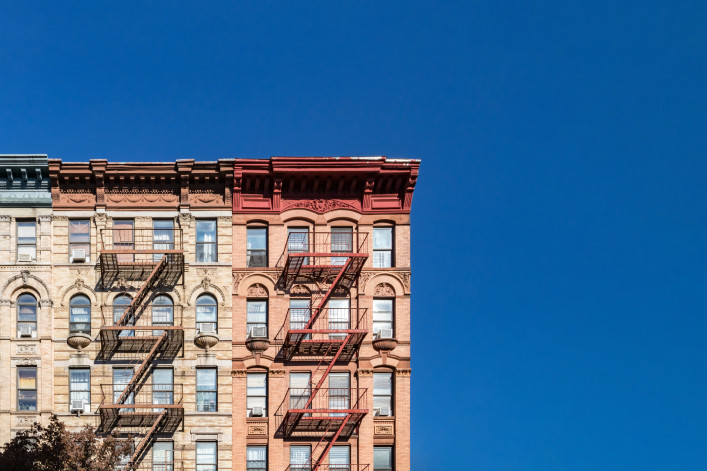 Colorful historic buildings on 4th Street in the East Village of Manhattan in New York City with empty blue sky background