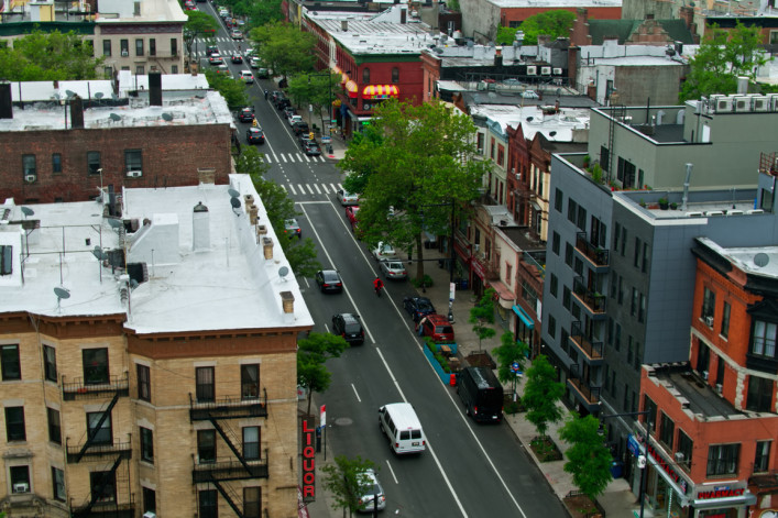 New York City on a hazy day in summer, following traffic on Nostrand Avenue in Crown Heights, Brooklyn.