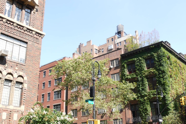 New York City classic building corner architecture. Urban residential house exterior. Real estate property in USA. Typical brick facade, Irving Pl, Manhattan Midtown. Rooftop water tower. Green wall.