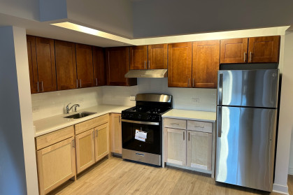 Kitchen with appliances, white countertop and hardwood floors