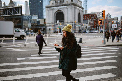 Commuter having a pizza slice on the go in Manhattan, New York.