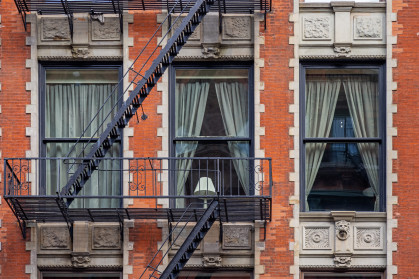 Lamp in a window as part of the façade of a residential building in central Manhattan