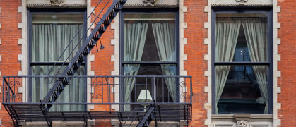 Lamp in a window between fire escape stairs