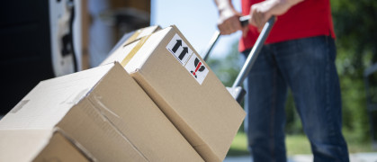 Shot of unrecognizable delivery guy pushing cart full of parcels. stock photo