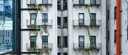 In New York City, United States this older residential building viewed from the High Line has old fashioned fire escapes visible on its exterior.