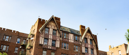 Large apartment building in Bedford Park in the Bronx stands out against a clear blue sky in New York, USA.