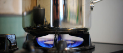 stainless steel saucepan being used on a gas cooktop