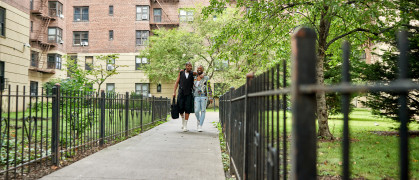 New Yorkers on pedestrian walkway between apartment buildings.