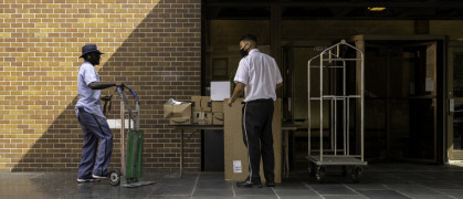 Postman transferring packages to the doorman of a residential building on Madison Avenue